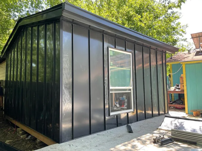 Black standing seam metal wall panels for Roof Inspection in Brick